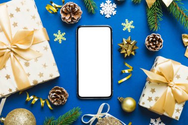 Digital phone mock up with rustic Christmas decorations for app presentation top view with empty space for you design. Christmas online shopping concept. Tablet with copy space on colored background.