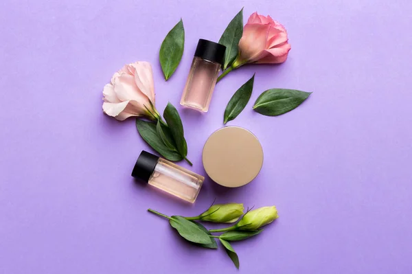 Composition with cosmetic products and beautiful roses on color background. Flat lay.