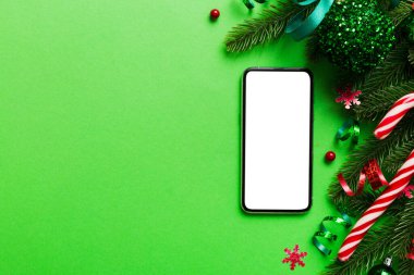 Digital phone mock up with rustic Christmas decorations for app presentation top view with empty space for you design. Christmas online shopping concept. Tablet with copy space on colored background.