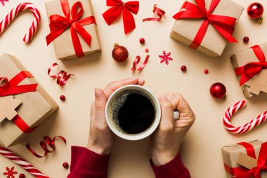 Elinde bir fincan kahve tutan kadın. Kadın elleri bardağı sıcak kahveyle tutuyor. Kış ve Noel zamanı kavramı.
