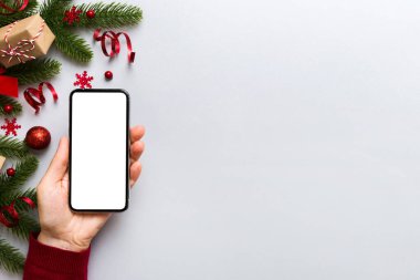 Digital phone mock up with rustic Christmas decorations for app presentation top view with empty space for you design. Christmas online shopping concept. Tablet with copy space on colored background.