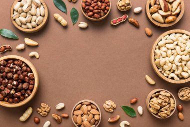 mixed nuts in wooden bowl. Mix of various nuts on colored background. pistachios, cashews, walnuts, hazelnuts, peanuts and brazil nuts.
