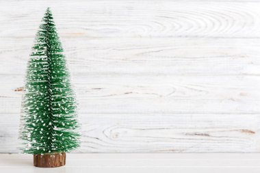 One small Christmas tree on colored background. new year decoration with copy space.