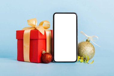 Digital phone mock up with rustic Christmas decorations for app presentation with empty space for you design. Christmas online shopping concept. Tablet with copy space on colored background.