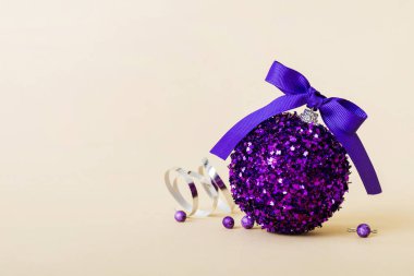 Christmas ball on colored background. decoration bauble with ribbon bow with copy space.