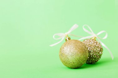 Christmas ball on colored background. decoration bauble with ribbon bow with copy space.