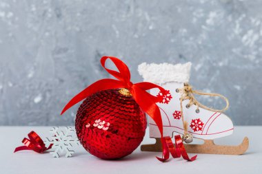 Christmas ball with skates on colored background. decoration bauble with ribbon bow with copy space.