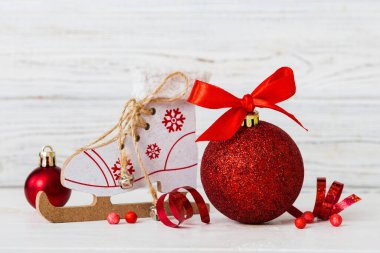 Christmas ball with skates on colored background. decoration bauble with ribbon bow with copy space.