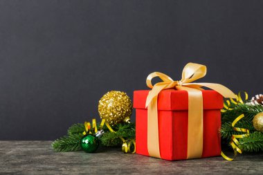 New Year Christmas mood, gift box, branches of a christmas tree, New Year decorations on a colored background.