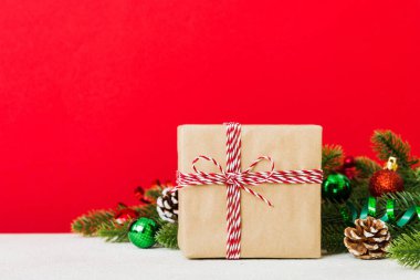 New Year Christmas mood, gift box, branches of a christmas tree, New Year decorations on a colored background.