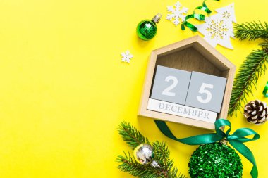 Christmas calendar 25 december. Christmas gift, fir branches, pine cones. Flat lay, top view. New Year decorations on a colored background.