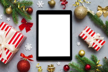 Digital tablet mock up with rustic Christmas decorations for app presentation top view with empty space for you design. Christmas online shopping concept. Tablet with copy space on colored background.