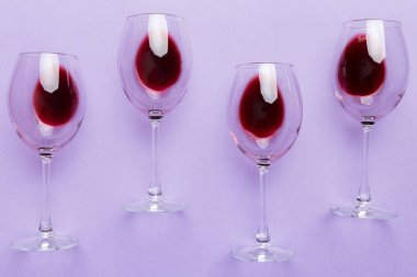 Şarap tadımında bir sürü kırmızı şarap. Renkli arka planda kırmızı şarap kavramı. Üst görünüm, düz dizayn.