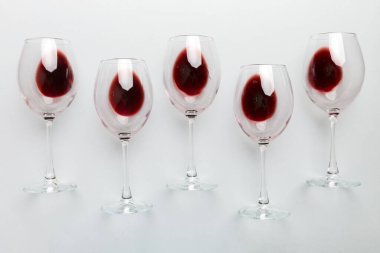 Şarap tadımında bir sürü kırmızı şarap. Renkli arka planda kırmızı şarap kavramı. Üst görünüm, düz dizayn.