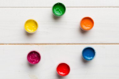 Renkli arka planda farklı renkte gagalı kavanozlar. Hobi resim. Boşluğu olan üst görünüm. Yaratıcılık için işyeri. ev öğretmenliği kavramı çizimi.