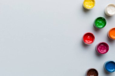 Renkli arka planda farklı renkte gagalı kavanozlar. Hobi resim. Boşluğu olan üst görünüm. Yaratıcılık için işyeri. ev öğretmenliği kavramı çizimi.