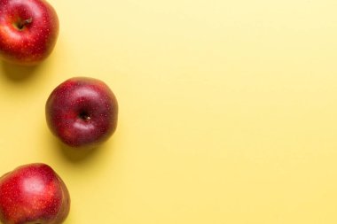 Renkli arka planda bir sürü kırmızı elma, üst manzara. Tasarım veya metin için kopyalama alanı olan taze elma görünümlü sonbahar deseni.