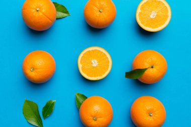 Renkli arka planda taze portakal dilimlerinin meyve deseni. Üst Manzara. Uzayı kopyala yaratıcı yaz konsepti. Minimum düzlükteki turunçgillerin yarısı.