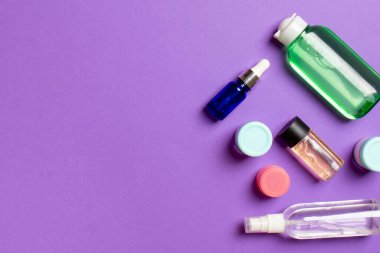 Kozmetik SPA marka modeli, fotokopi alanı olan üst görünüm. Renkli arka planda duran krema tüpleri ve kavanozları..