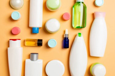 Plastik gövde bakımı şişesi düz kompozisyonu ve renkli arka plan boşluğuna kozmetik ürünler dizayn edilmişti. Beyaz Kozmetik kapları kümesi, kopya alanı ile üst görünüm.