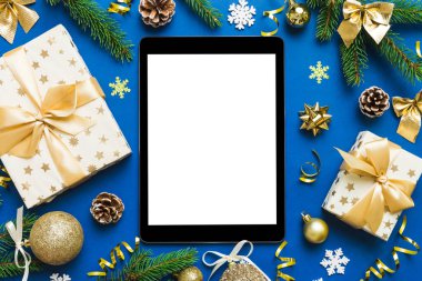 Digital tablet mock up with rustic Christmas decorations for app presentation top view with empty space for you design. Christmas online shopping concept. Tablet with copy space on colored background.