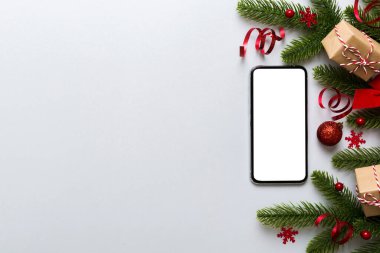 Digital phone mock up with rustic Christmas decorations for app presentation top view with empty space for you design. Christmas online shopping concept. Tablet with copy space on colored background.