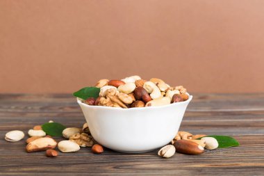 mixed nuts in bowl. Mix of various nuts on colored background. pistachios, cashews, walnuts, hazelnuts, peanuts and brazil nuts.