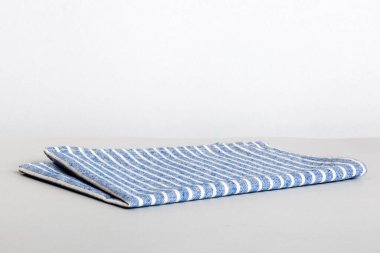 top view with blue kitchen napkin isolated on table background. Folded cloth for mockup with copy space, Flat lay. Minimal style.