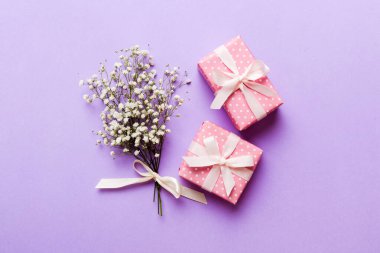 Hediye kutusu ya da hediye kutusu ve çiçek çıngıraklı yılanı ışık masasının üstünde. Tebrik kartı. Kopya alanı ile düz uzanma biçimi.