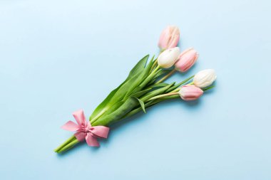 Renkli masa arkasında bir buket pembe lale. Kopyalama alanı olan üst görünüm. Baharı bekliyorum. Mutlu Paskalyalar. Düz yatıyordu.