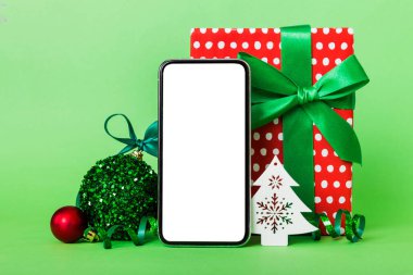 Digital phone mock up with rustic Christmas decorations for app presentation with empty space for you design. Christmas online shopping concept. Tablet with copy space on colored background.