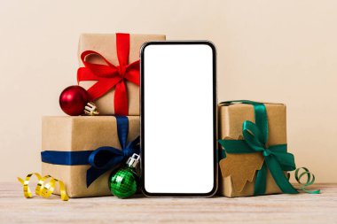 Digital phone mock up with rustic Christmas decorations for app presentation with empty space for you design. Christmas online shopping concept. Tablet with copy space on colored background.