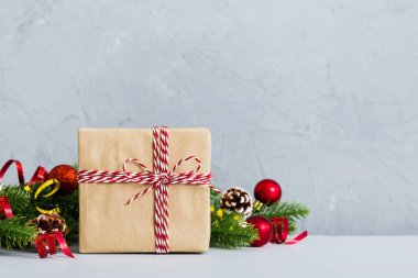 New Year Christmas mood, gift box, branches of a christmas tree, New Year decorations on a colored background.