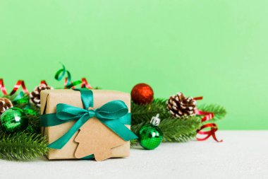 New Year Christmas mood, gift box, branches of a christmas tree, New Year decorations on a colored background.