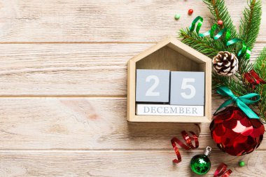 Christmas calendar 25 december. Christmas gift, fir branches, pine cones. Flat lay, top view. New Year decorations on a colored background.