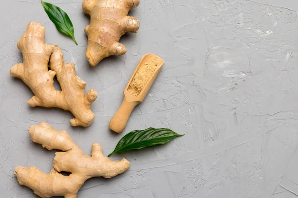 Finely dry Ginger powder in bowl with green leaves isolated on colored background. top view flat lay.