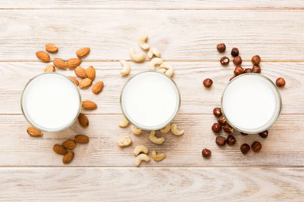 Set or collection of various vegan milk almond, cashew, on table background. Vegan plant based milk and ingredients, top view.