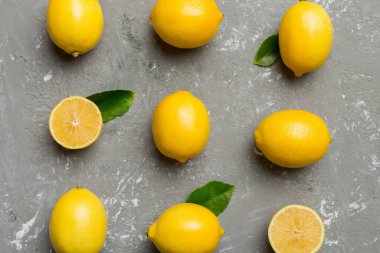 Renkli arka plan olarak pek çok taze limon, üst manzara. Limon ve limon dilimlerinin zarif arka planı Üst görünüm düz yatıyordu.