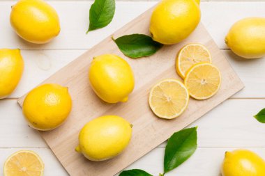 Kesme tahtasındaki taze ve olgun limonlar için fotokopi alanı olan üst manzara. Sağlıklı yemek geçmişi. Limon ve limon dilimlerinin zarif arkaplanı daha sıkan renkli arkaplan.