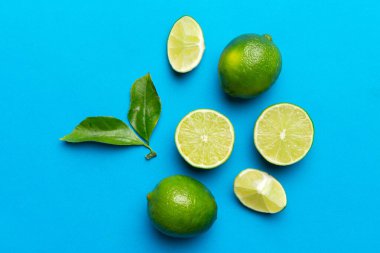 Yeşil yapraklı kireç meyveleri ve beyaz arka planda yarım dilim kesilmiş. Üst Manzara. Kopyalama alanı olan düz.