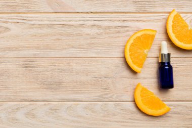 Portakal meyveli şişeler ahşap arka planda gerekli yağ. Kopyalama alanı olan alternatif tıp üst görünümü.