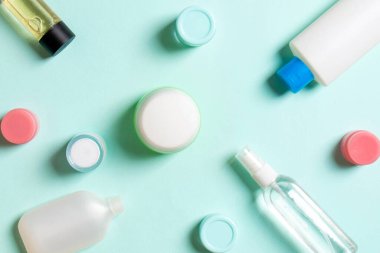 Plastik gövde bakımı şişesi düz kompozisyonu ve renkli arka plan boşluğuna kozmetik ürünler dizayn edilmişti. Beyaz Kozmetik kapları kümesi, kopya alanı ile üst görünüm.