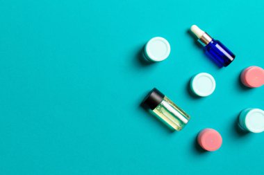 Kozmetik SPA marka modeli, fotokopi alanı olan üst görünüm. Renkli arka planda duran krema tüpleri ve kavanozları..