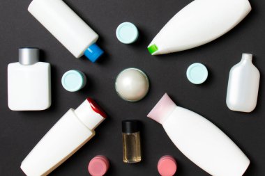 Renkli arka plandaki kozmetik ürünleri için farklı boyutlarda şişeler ve kavanozlar. Fotokopi alanı ile yüz ve vücut bakımı kavramı.