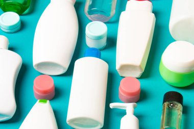 Renkli arka plandaki kozmetik ürünleri için farklı boyutlarda şişeler ve kavanozlar. Fotokopi alanı ile yüz ve vücut bakımı kavramı.