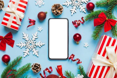 Digital phone mock up with rustic Christmas decorations for app presentation top view with empty space for you design. Christmas online shopping concept. Tablet with copy space on colored background.