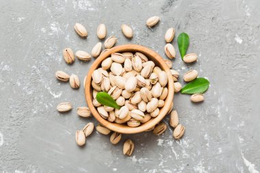 Fresh healthy Pistachios in bowl on colored table background. Top view. Healthy eating concept. Super foods.