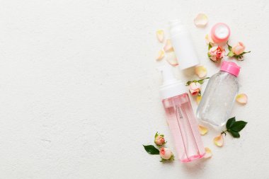 Serum, mikiler, tonik, losyon, gül çiçekli su ve krema için süslü sağlık şişeleri. Doğal orantılı spa kozmetik konsepti. Model, şablon, Üst Görünüm.