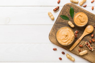 Arka planda bir kase fıstık ezmesi ve fıstık. Kopyalama alanı olan üst görünüm. Küçük kasede kremalı fıstıklı makarna.