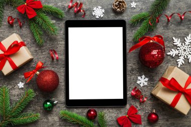 Digital tablet mock up with rustic Christmas decorations for app presentation top view with empty space for you design. Christmas online shopping concept. Tablet with copy space on colored background.